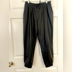 Black faux leather joggers in Medium, with drawstring waist. Scoop brand